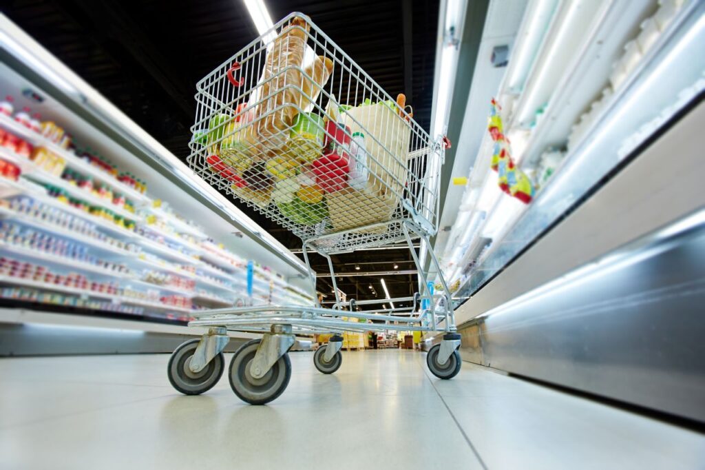 Grocery cart in supermarket aisle.